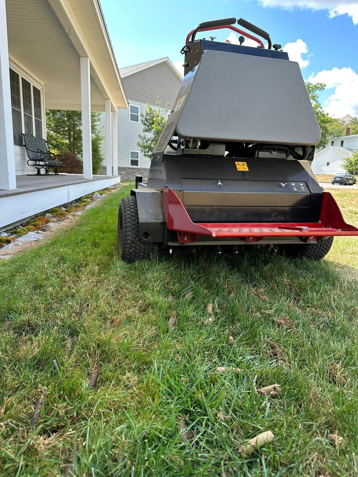 Core aerator machine pulling plugs on residential lawn by Kyle Poirier Landscaping LLC